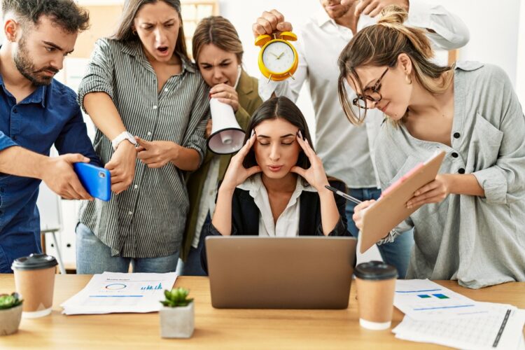 Group of business workers screaming to stressed partner at the office.